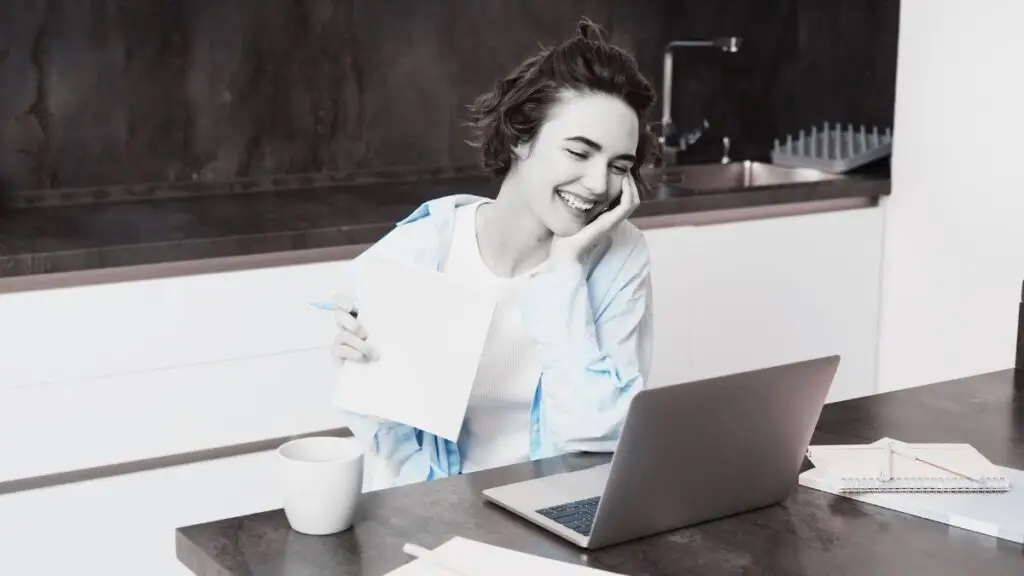 Joven sonriente leyendo el blog de Jurado Propiedad Raíz desde su laptop